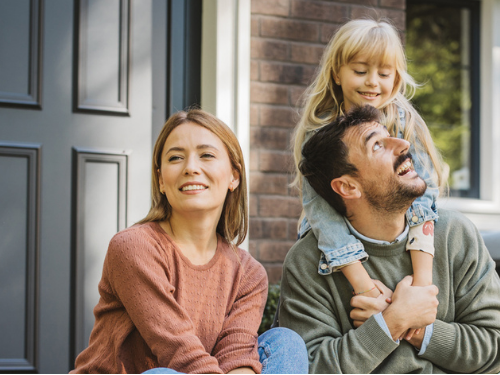 Family of three enjoying a moment together outside their home