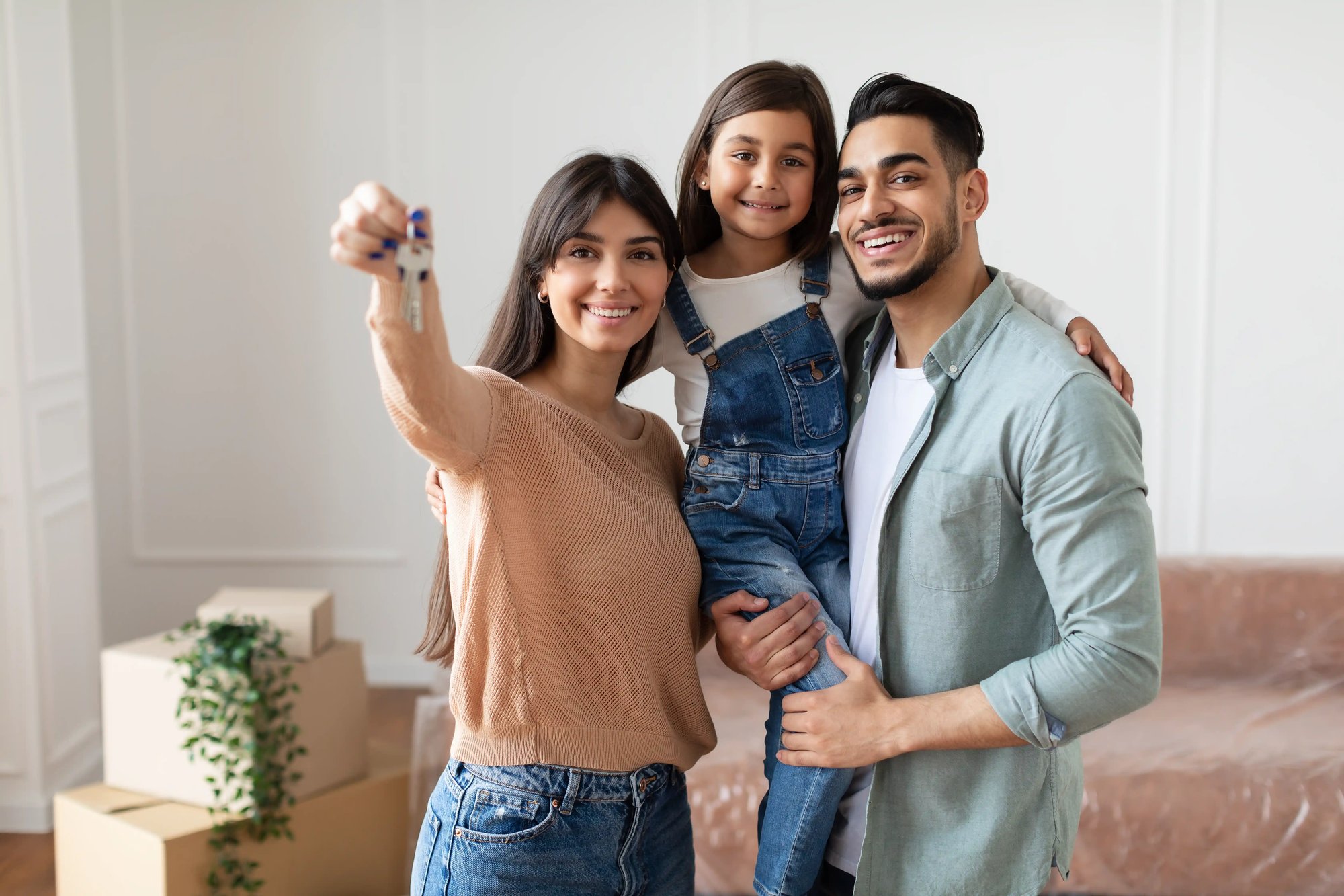 Young family standing together outside their home and smiling