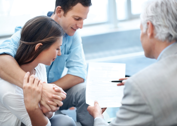 couple reviewing financial document with advisor.