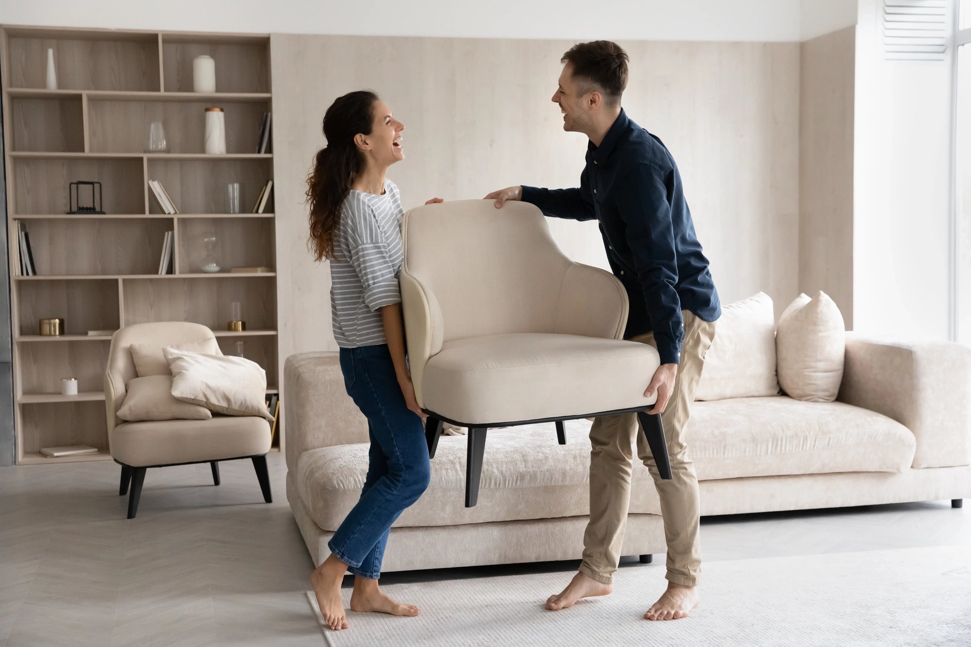 Laughing couple moving furniture.