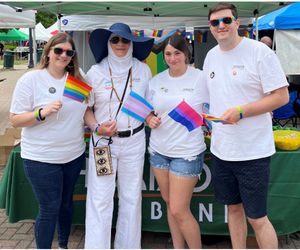 Horizon Bank employees hold colorful flags at a Pride event.