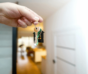 hands holding keys in front of a door