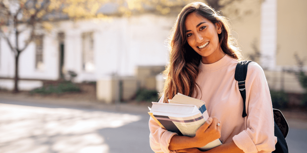 Girl standing outside holding school books
