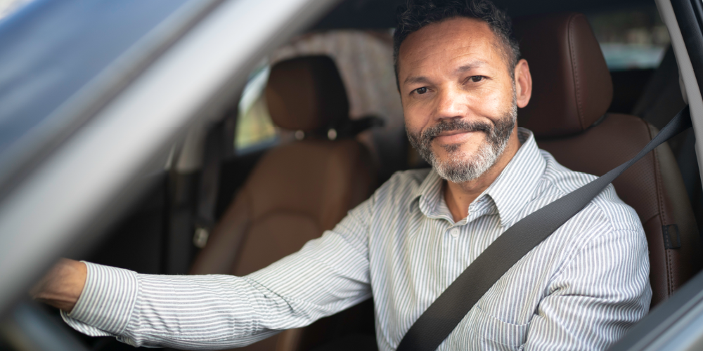 Man in car holding steering wheel
