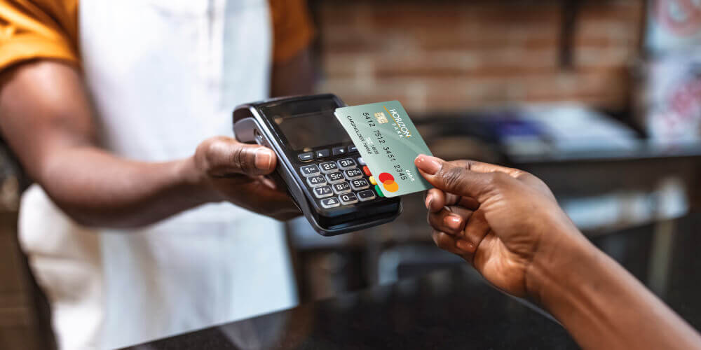person holding card reader and credit card