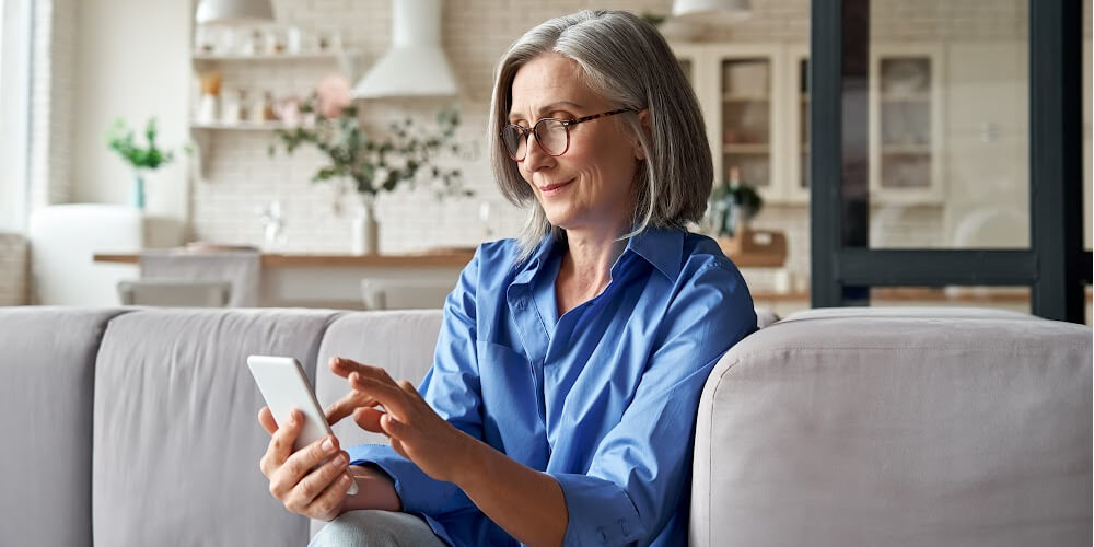 Woman sitting on couch holding phone