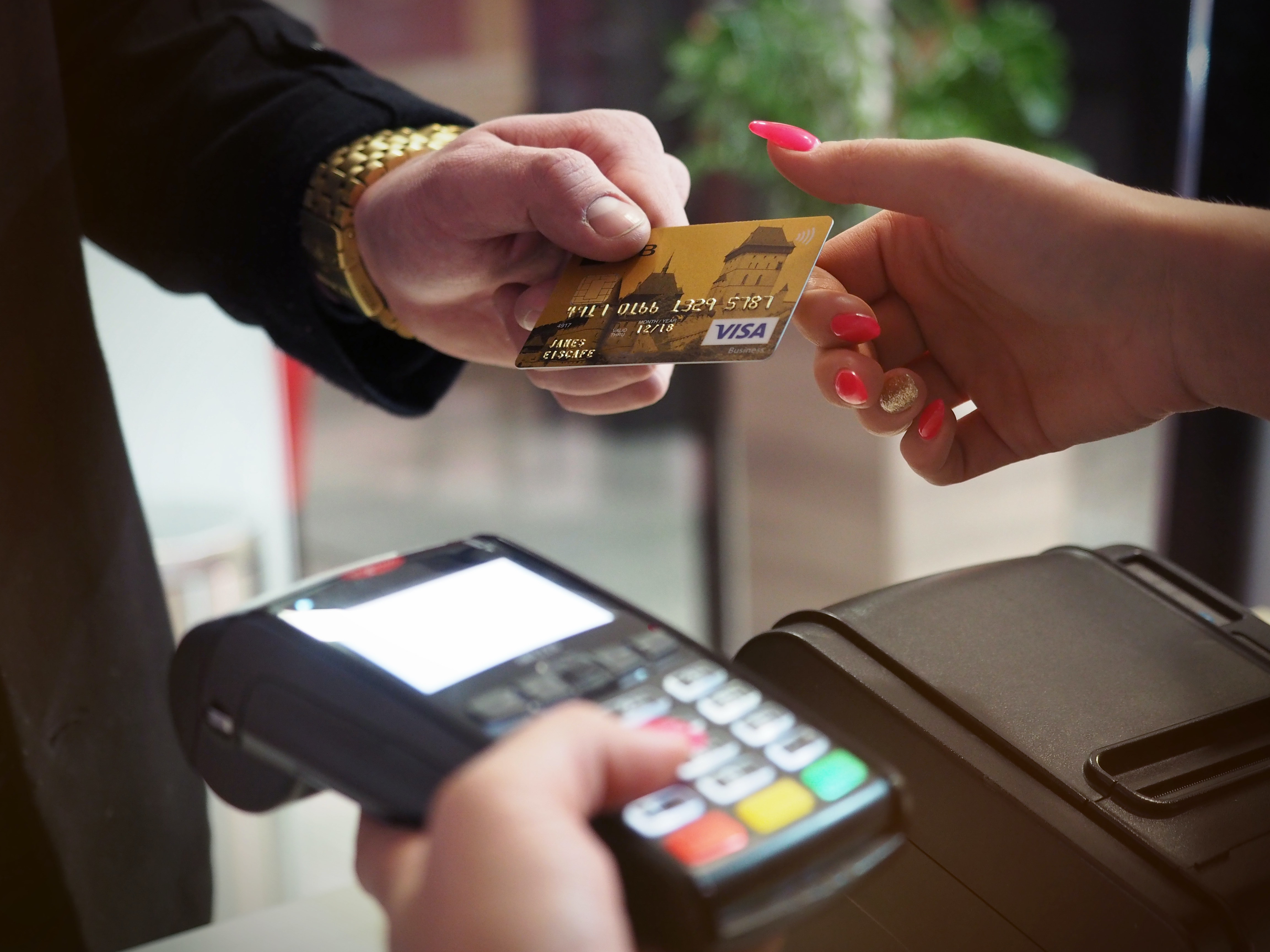 Woman handing credit card to store clerk